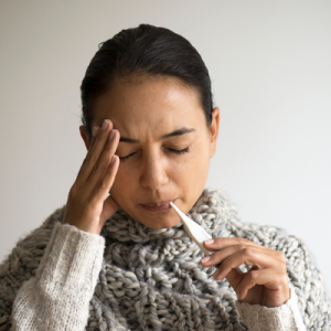 A women taking her temperature.