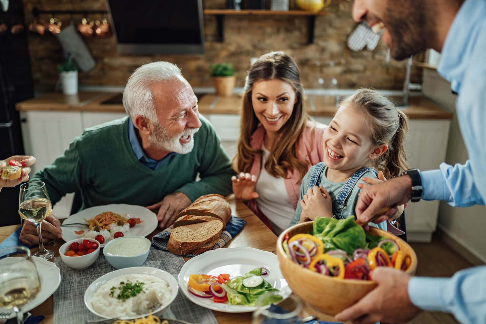 happy-extended-family-having-fun-while-talking-during-lunch-dining-room-focus-is-little-girl (1) (1)
